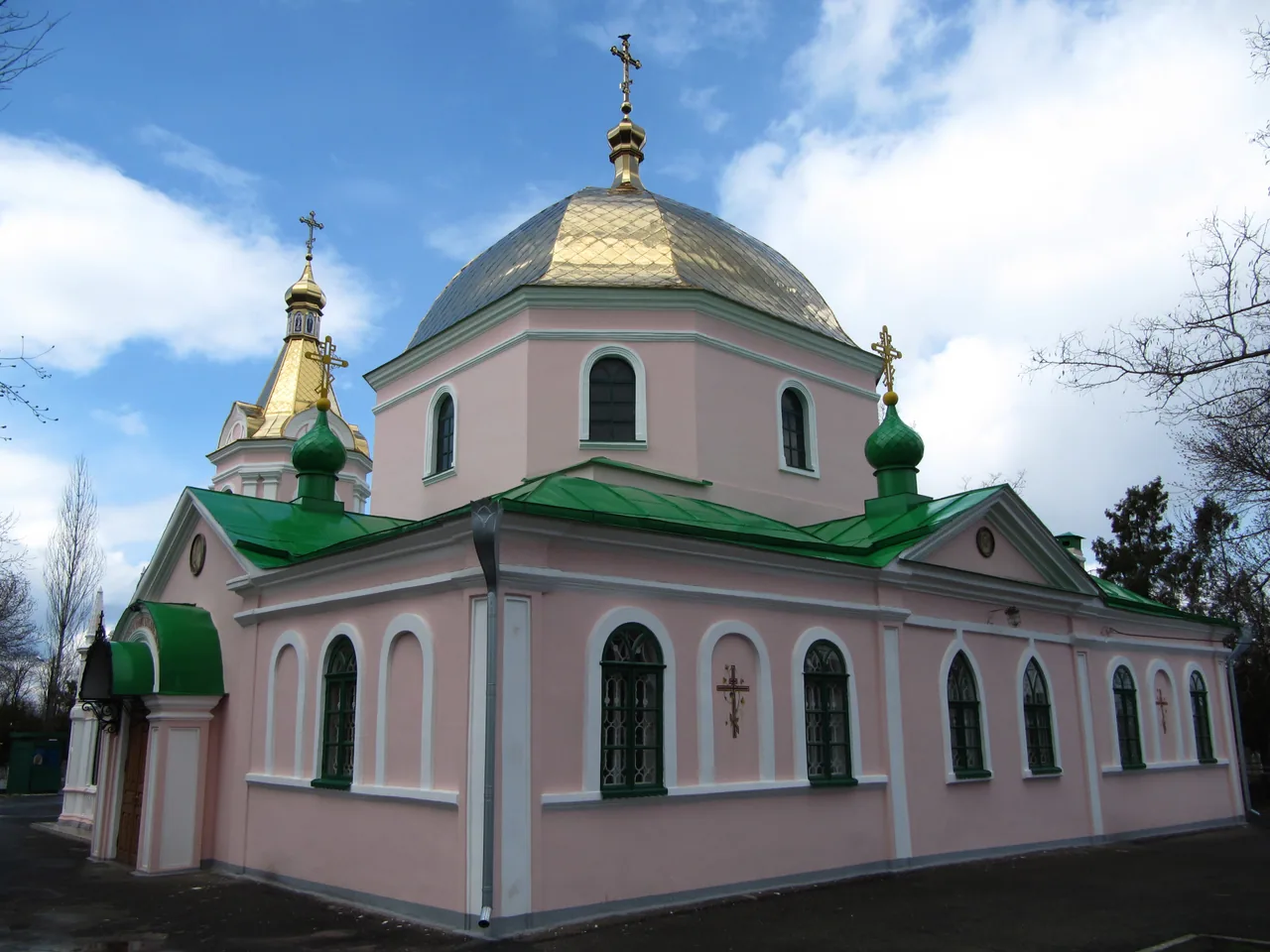 Архівний вигляд повного рожевого фасаду Церкви Всіх Святих у Миколаївському некрополі з банями, дзвіницею та входом.