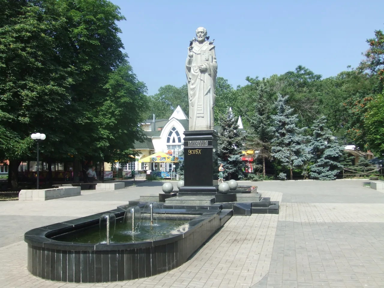 Пам’ятник Святому Миколаю зі світлого каменю на темному постаменті у Каштановому сквері Миколаєва.